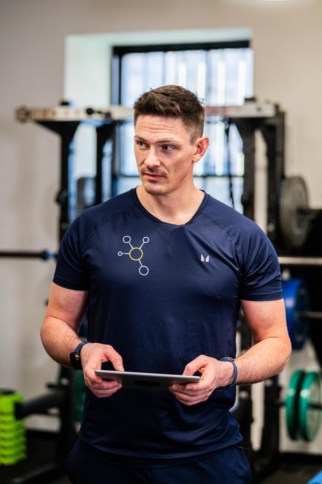 KA2_9398 Health by Science practitioner reviewing digital rehabilitation data on a tablet during a personal training Edinburgh session.