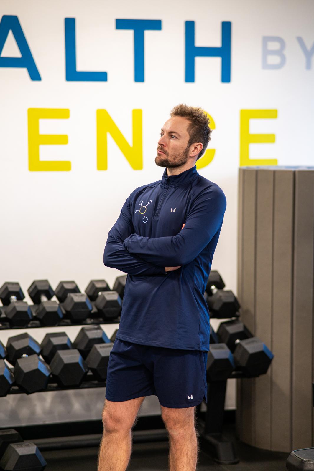 KA2_9518 Professional Health by Science coach monitoring a personal training Edinburgh session in front of a clinical strength wall.