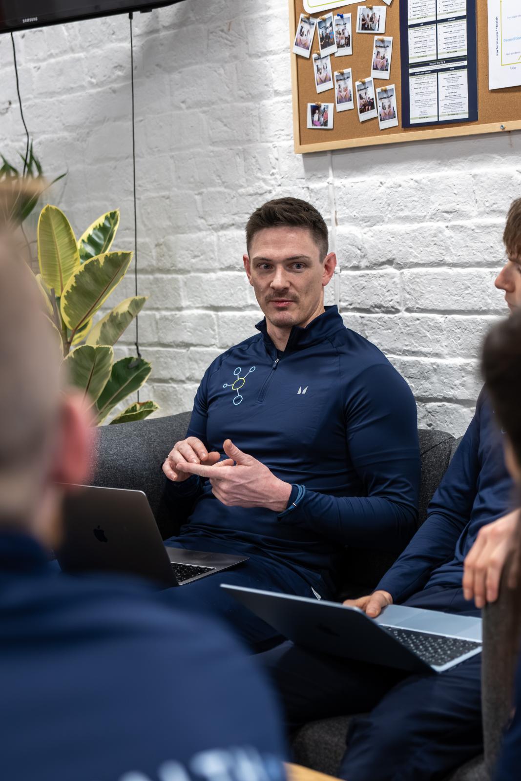 KA3_2078 Clinical specialist explaining biomechanical assessment data during a team consultation at our Leith gym.