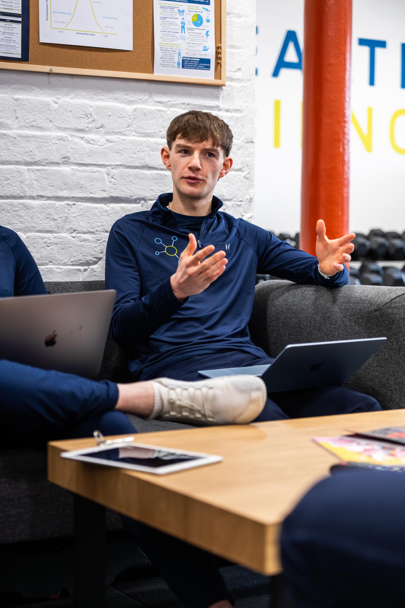 KA3_2225 Practitioner explaining evidence-based training methodologies during a clinical team meeting at the Health by Science Leith lab.
