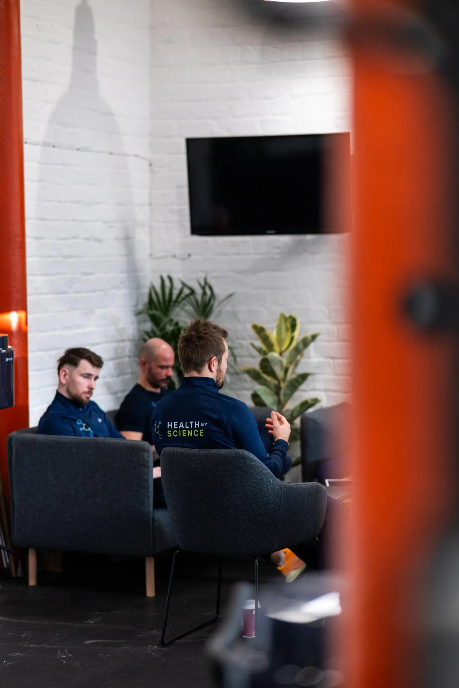 KA3_2417 Senior practitioners reviewing clinical data and patient progress tracking during a team meeting in our Leith gym.