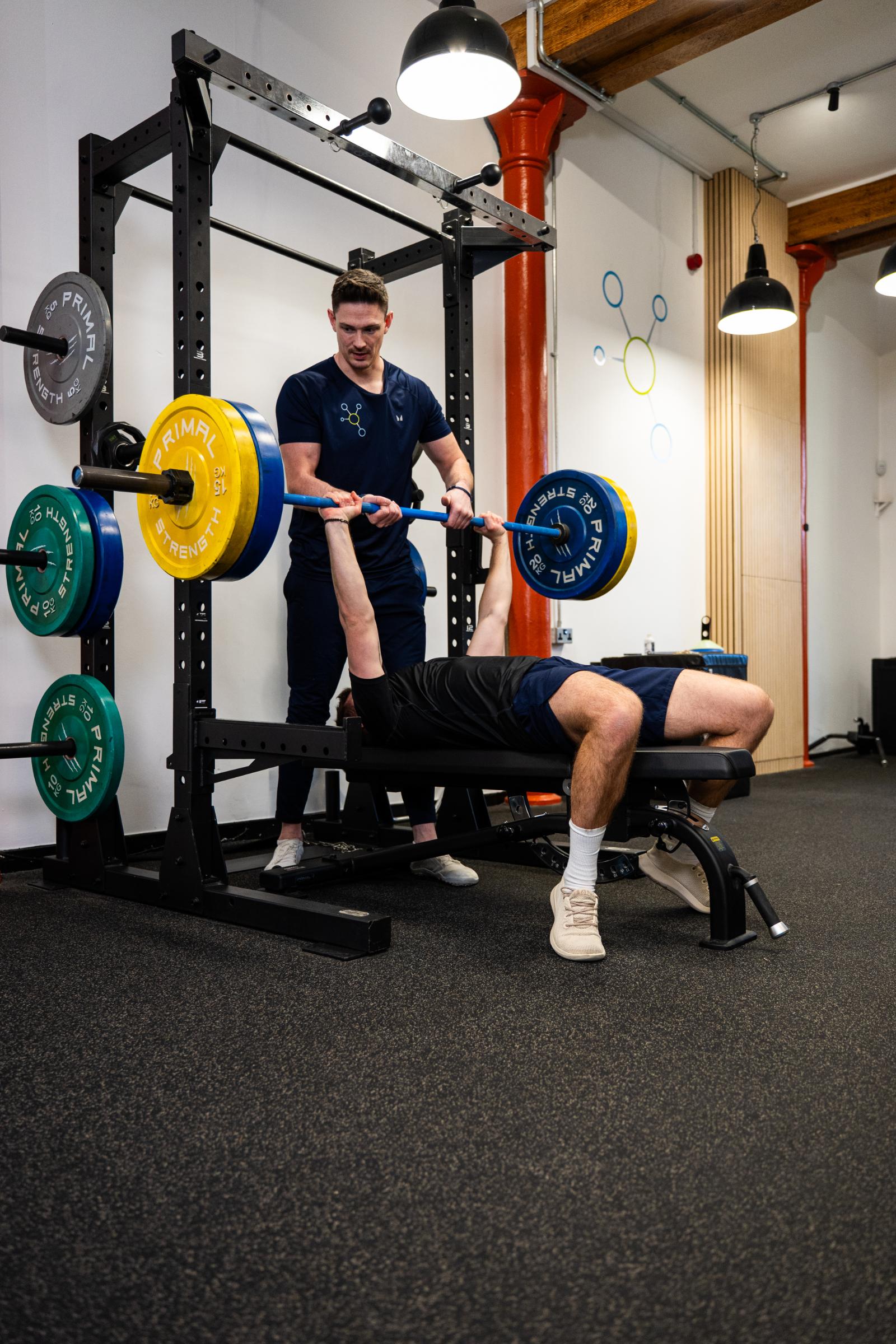 KA3_2466 Health by Science coach providing a safe spot and technical feedback during a clinical strength training session in Leith.