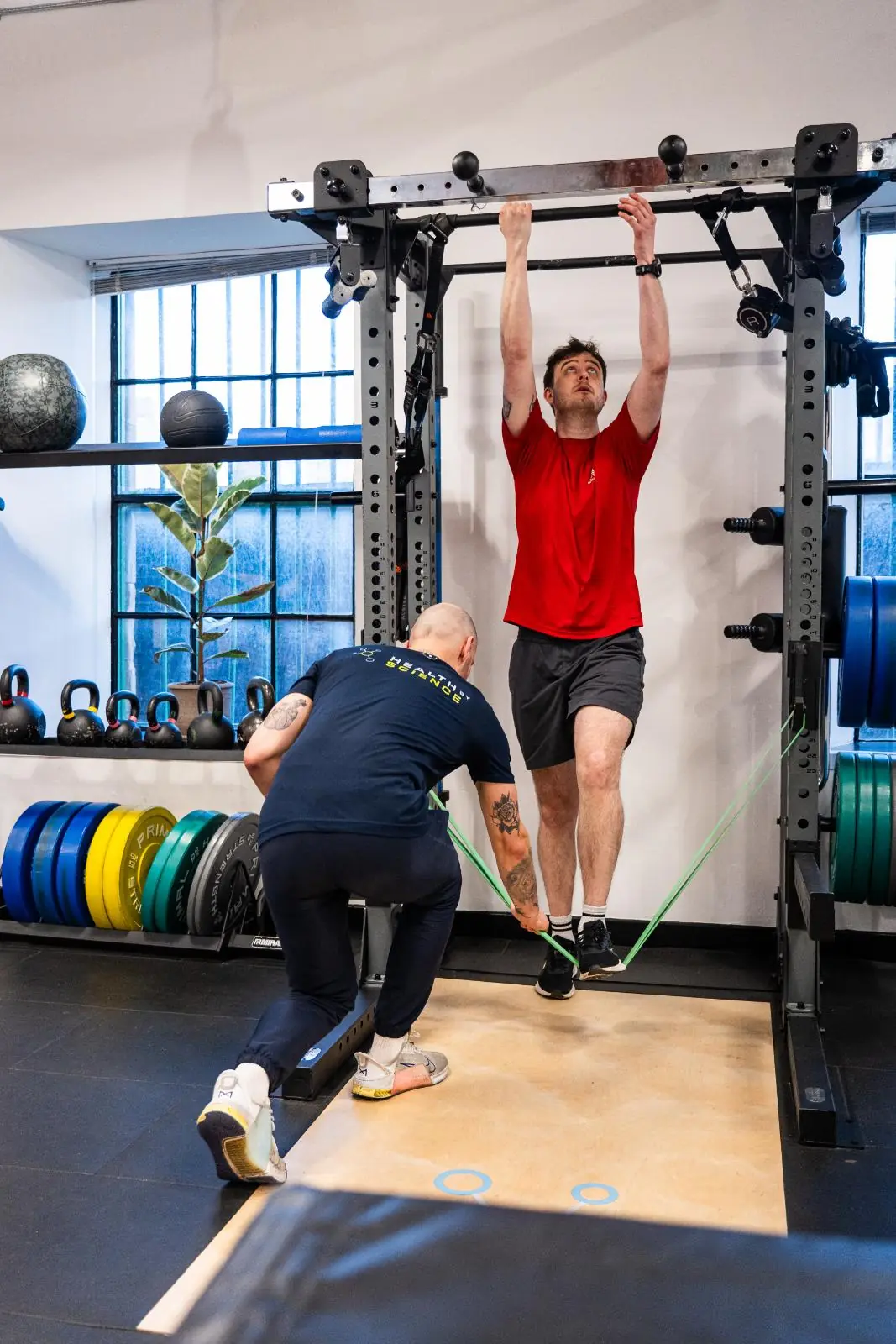 KA3_3285 Health by Science personal trainer edinburgh conducting a band-assisted movement assessment to improve upper limb strength at our Leith clinic.