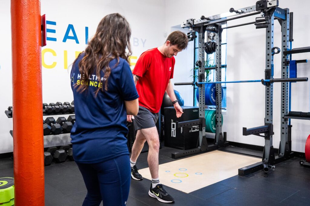 A Health by Science coach watching a client move during a Movement MOT in the Leith studio