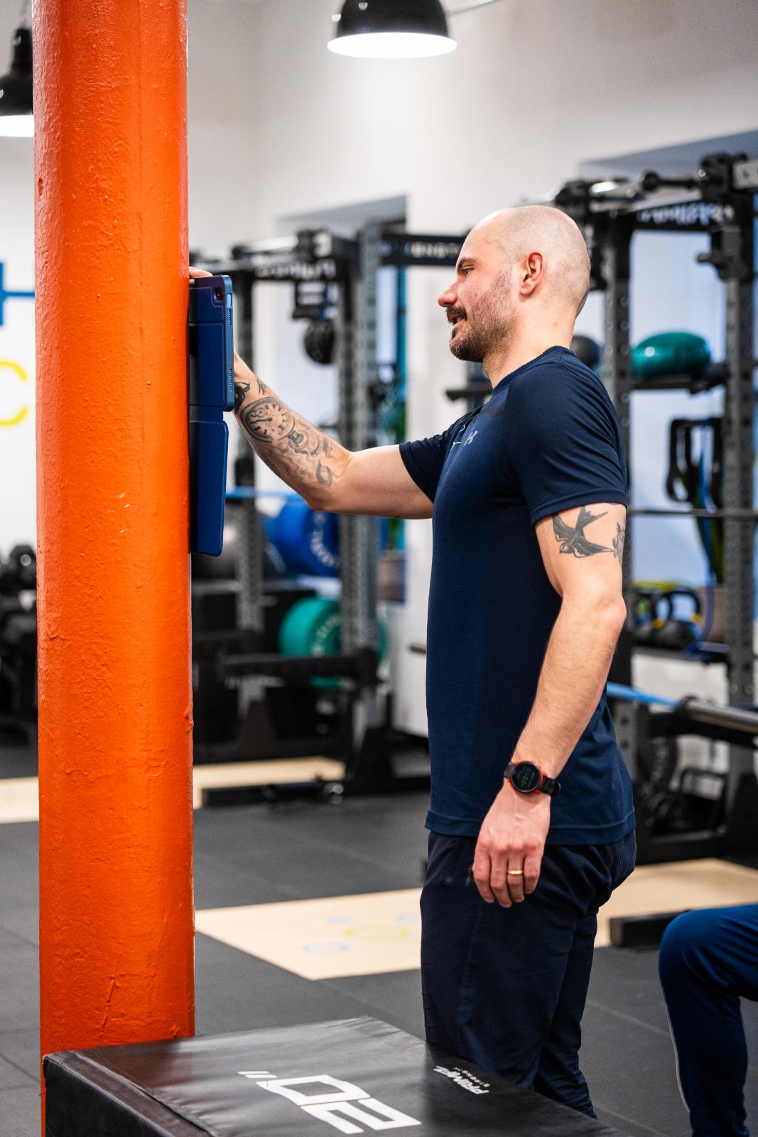 KA3_3393 Health by Science coach using proprietary digital tracking software to monitor biomechanical progress during a training session.