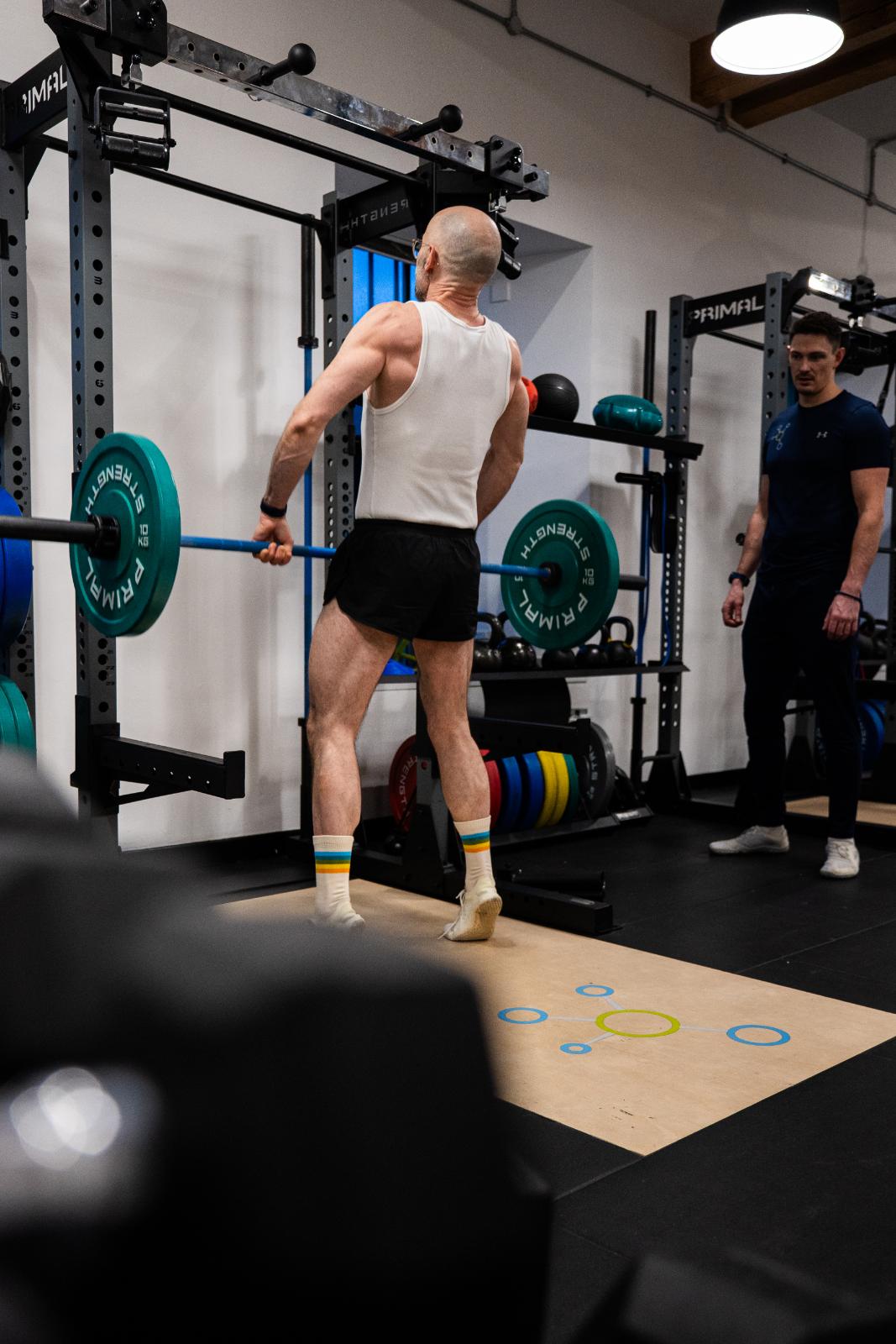 KA3_3417 Clinical supervision of a barbell clean and press to assess upper body explosive power and overhead stability.