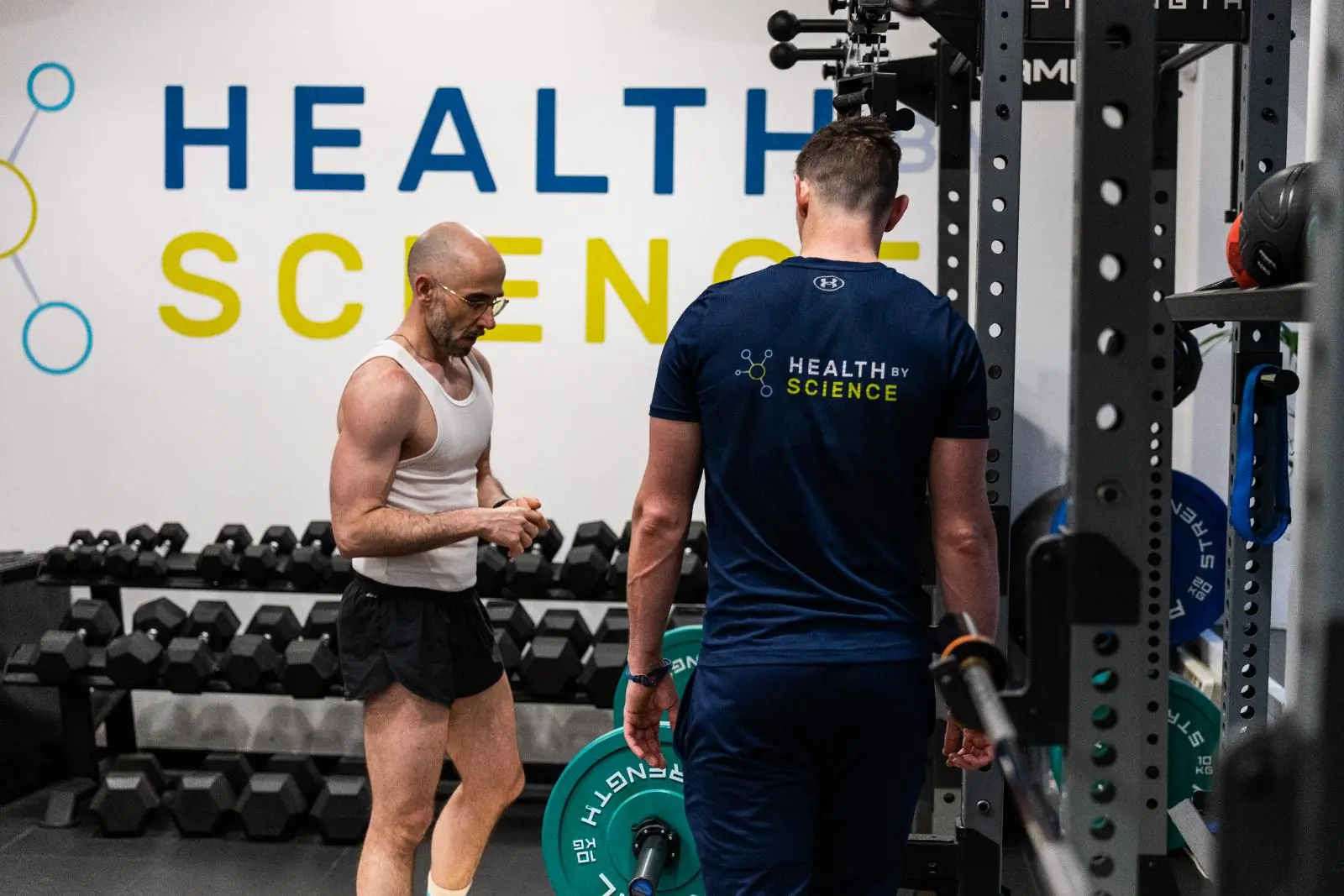 Specialist providing technical cues and clinical feedback during a barbell strength session at our specialised Leith clinic.