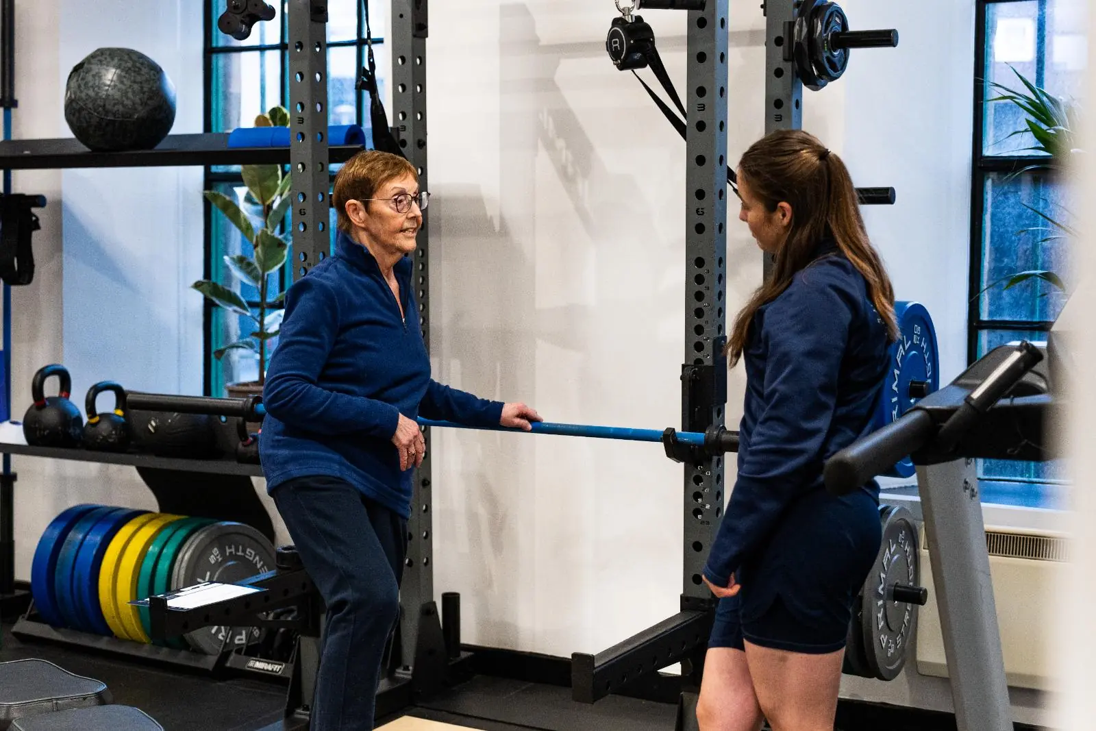 KA3_3845 Professional consultation between a Health by Science coach and a senior patient regarding safe barbell exercise progressions.