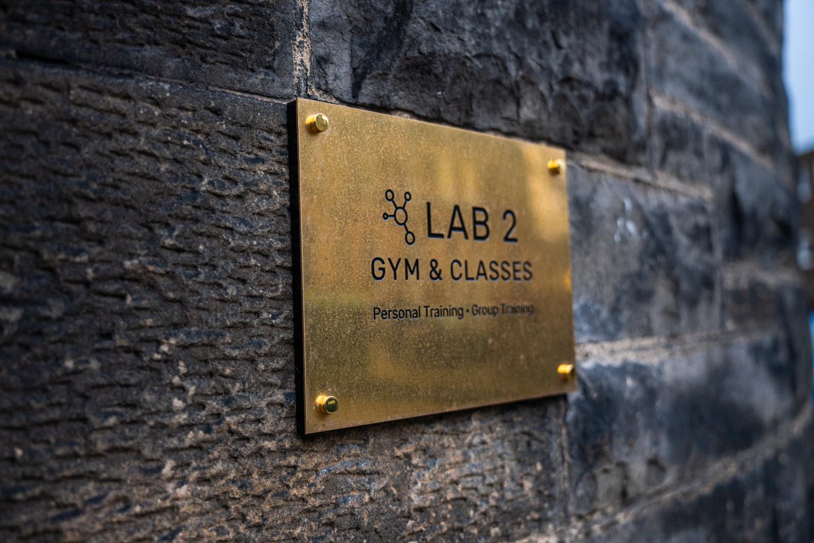Professional brass signage for Lab 2 Gym & Classes at Health by Science Leith, offering clinical personal training and group sessions.