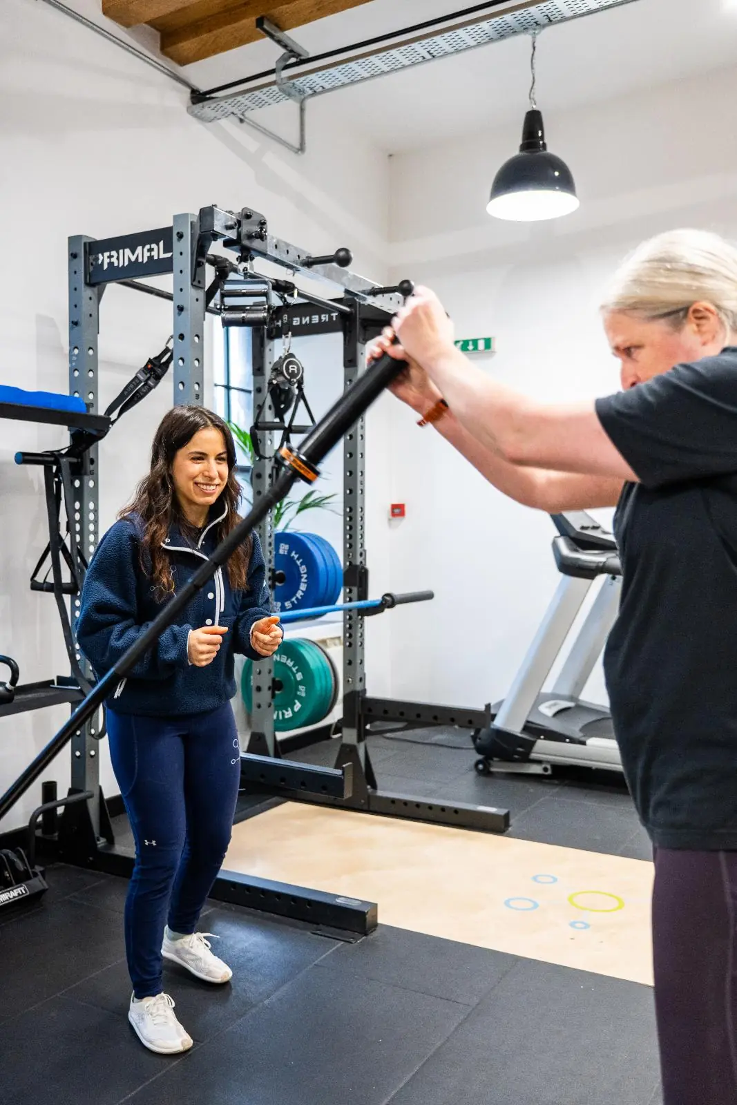 KA3_4134 Health by Science coach monitoring rotational movement mechanics to ensure joint safety during a high-intensity clinical session.