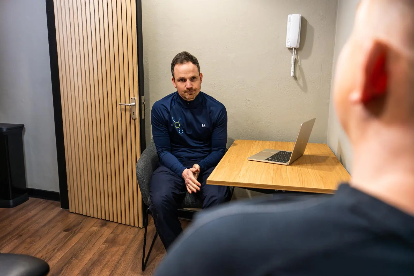 KA3_4607 Practitioner explaining evidence-based treatment plans and injury recovery timelines during a patient consultation in Leith.