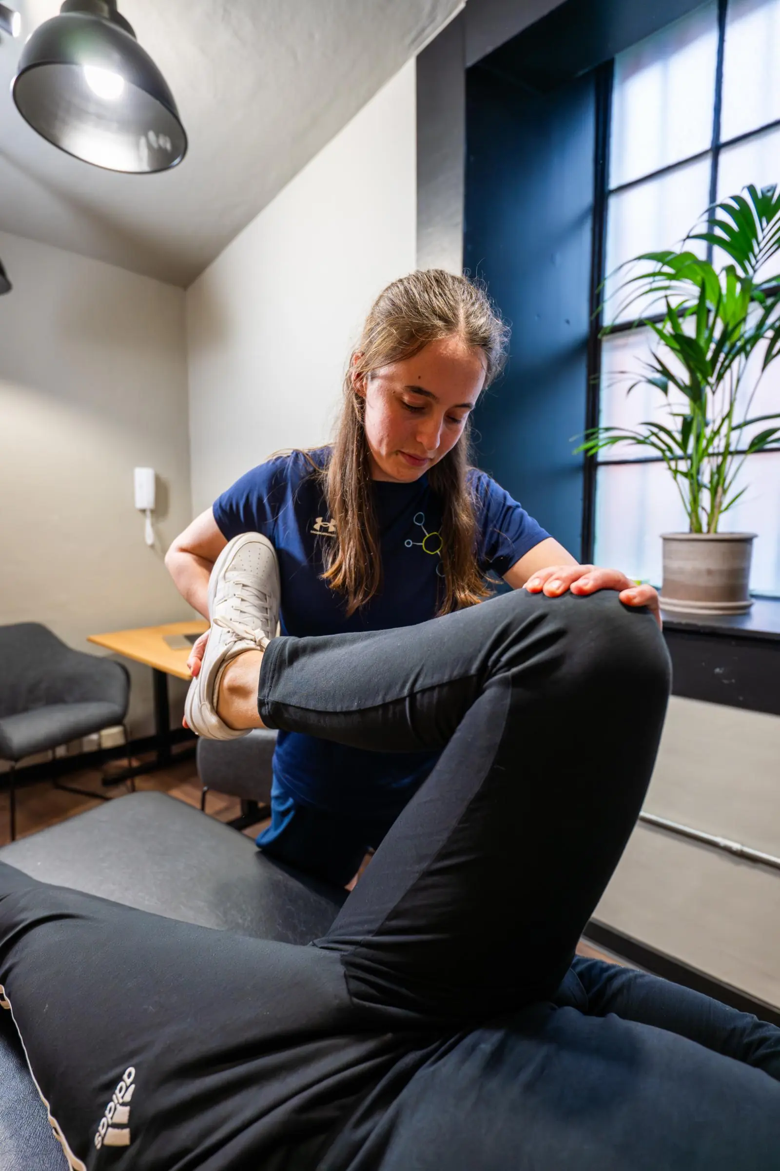 KA3_4973 Health by Science female physiotherapist edinburgh performing a manual hip and lower limb stretch to support patient injury recovery in Edinburgh.