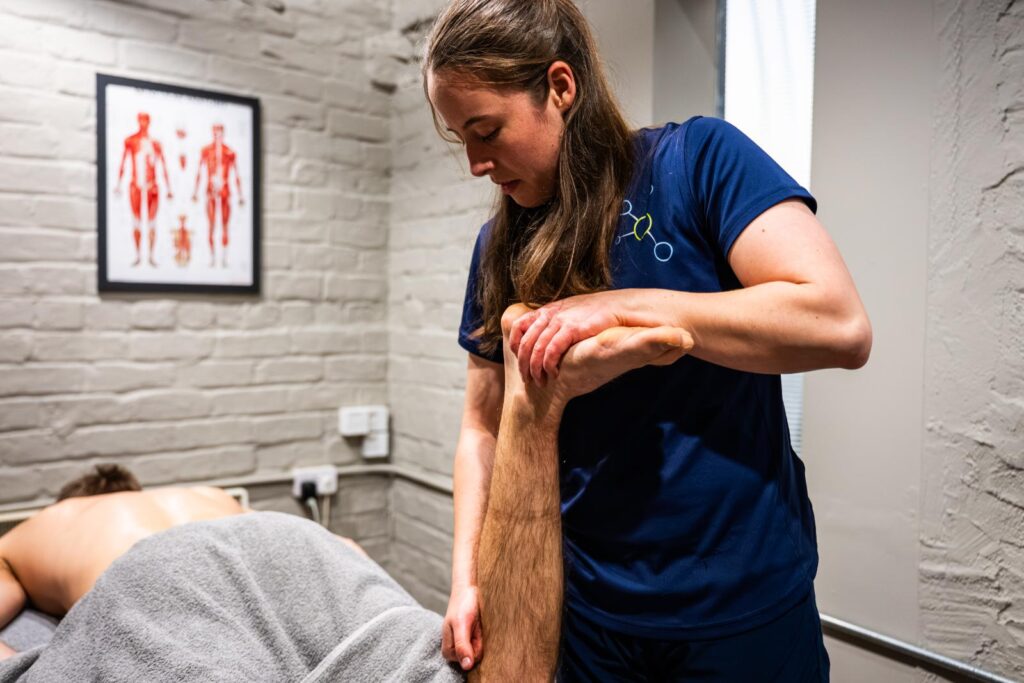 Health by Science practitioner performing manual mobilization of the ankle joint to enhance functional movement and performance.