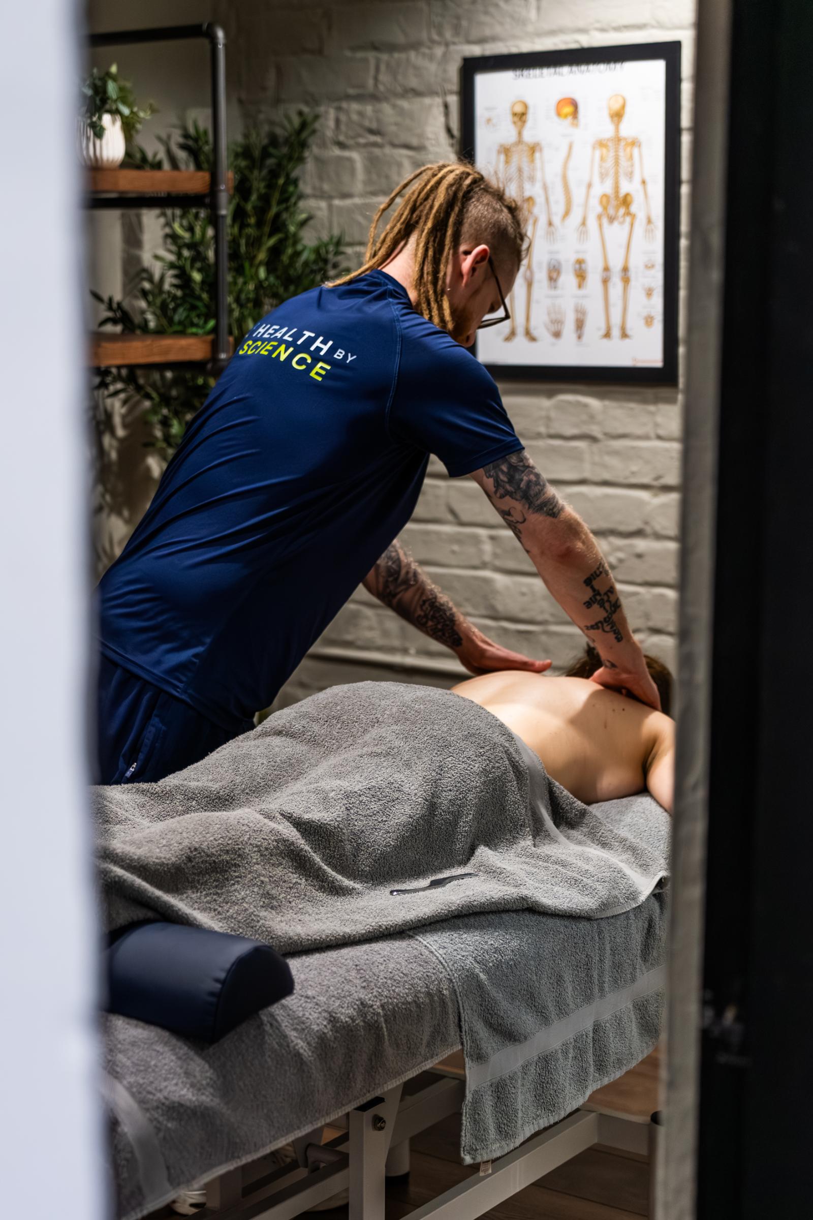 KA3_5682 Health by Science specialist performing a clinical sports massage edinburgh on a patient's upper back to relieve muscular tension in Leith.